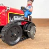 Tracteur mécanique rouge et son chauffeur